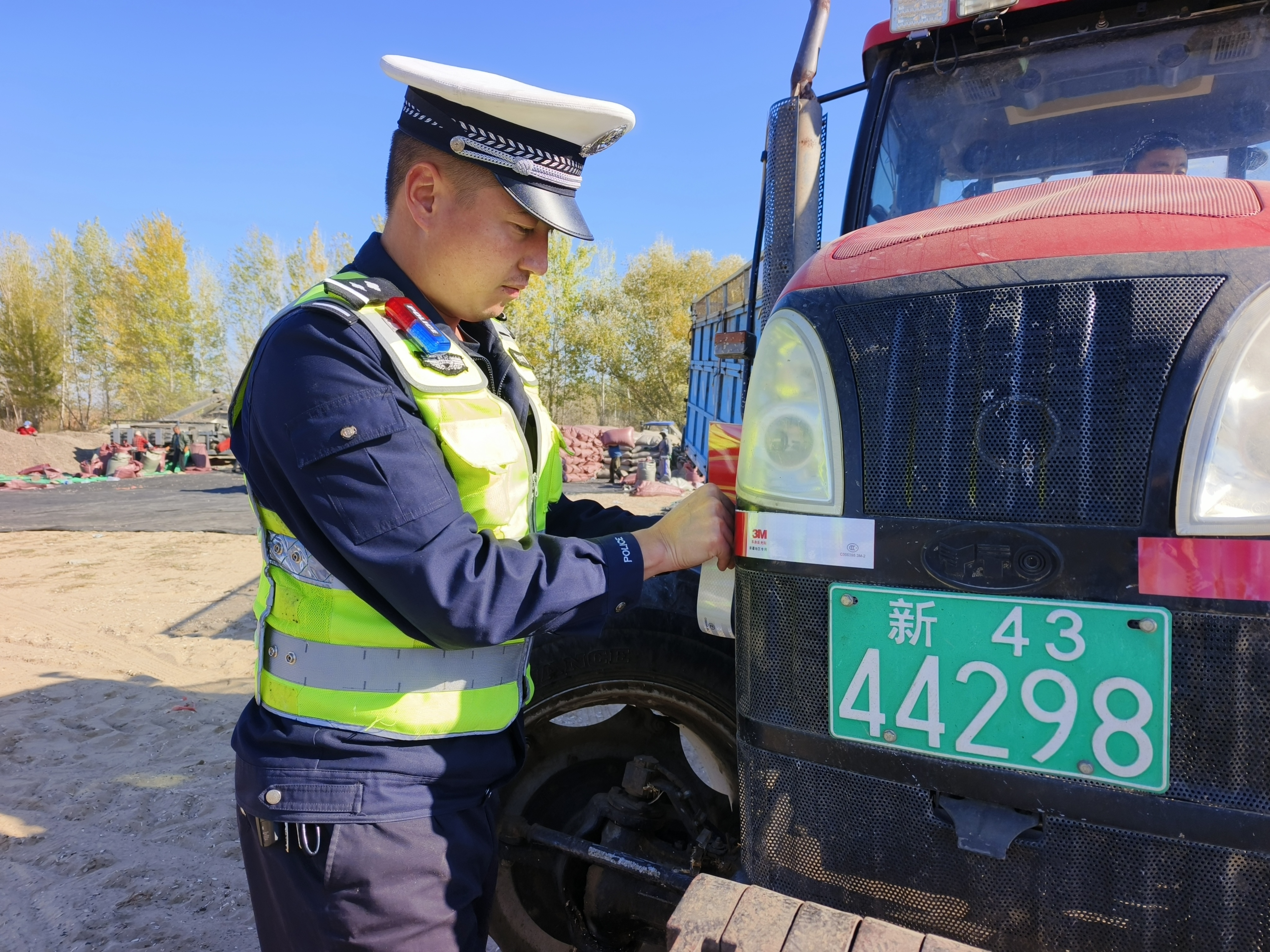 民警为农机车辆张贴反光贴.jpg