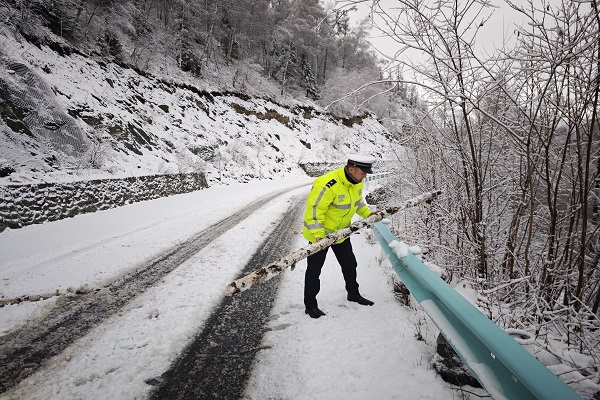 民警在山区道路清理道路安全隐患.jpg