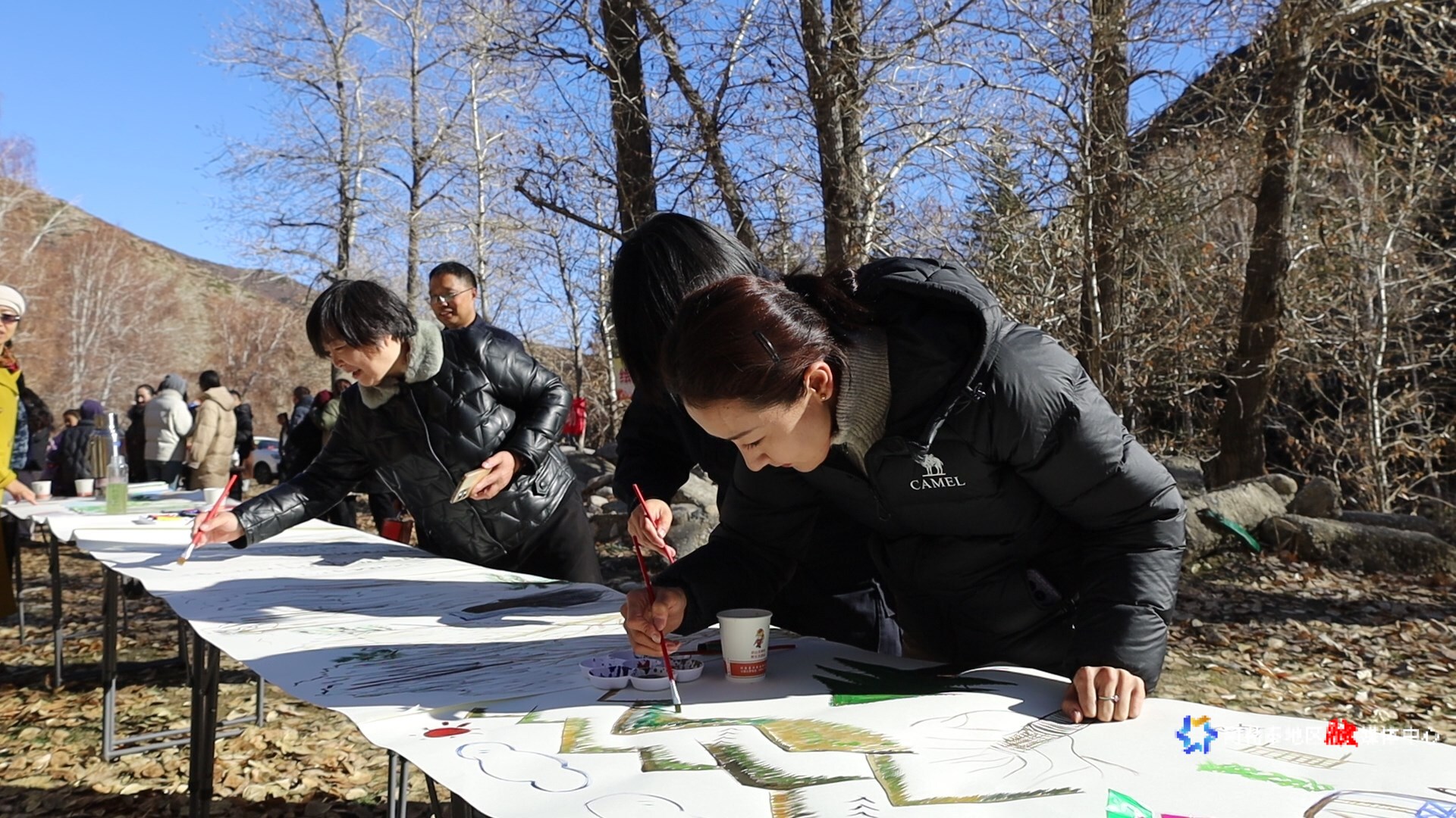 活动现场的创作区域，参与者们围绕着长桌，投入地进行主题绘画创作。